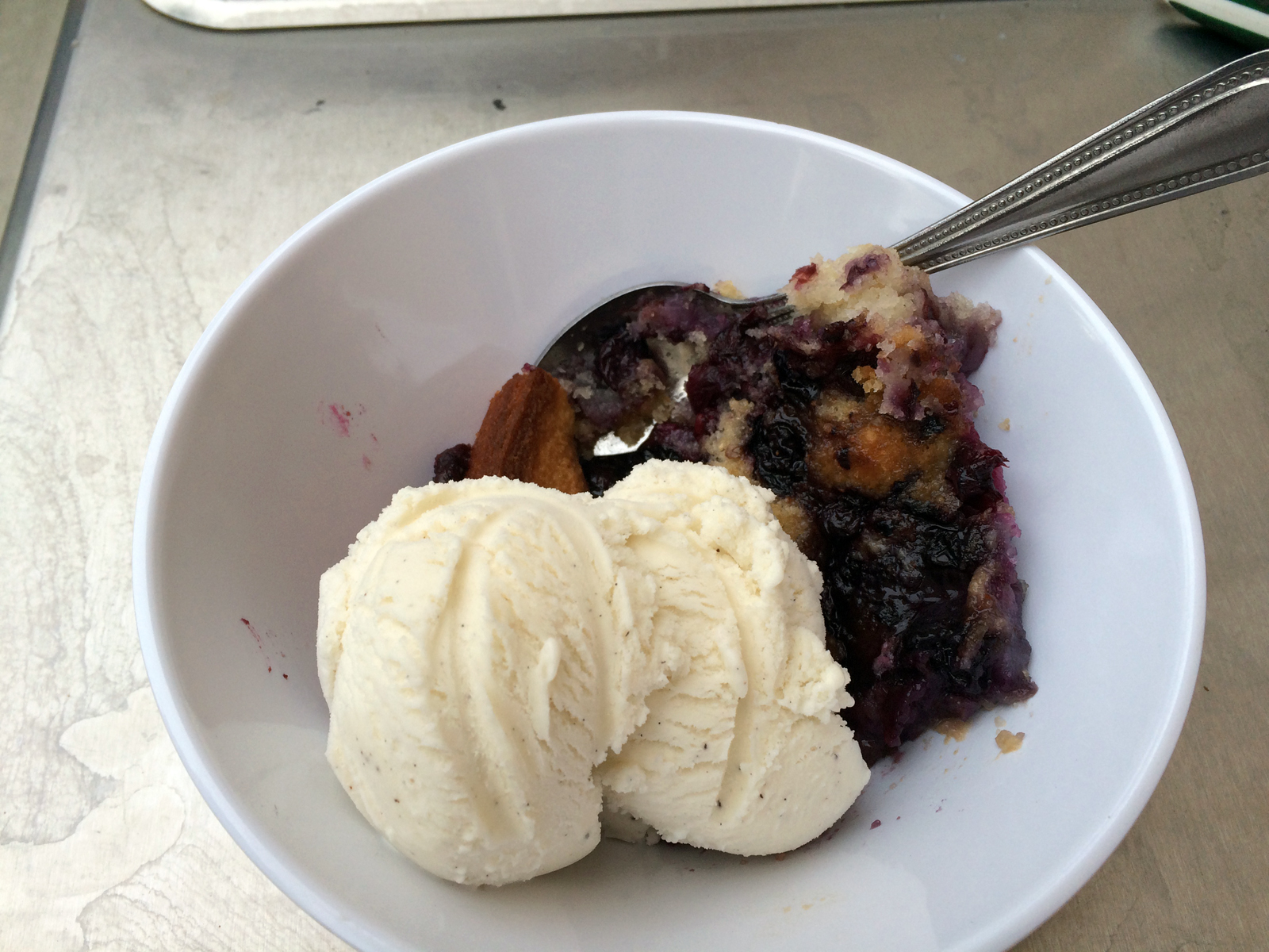 Golden-brown berry cobbler cake with a crispy sugar topping, bubbling with vibrant blueberries and raspberries.